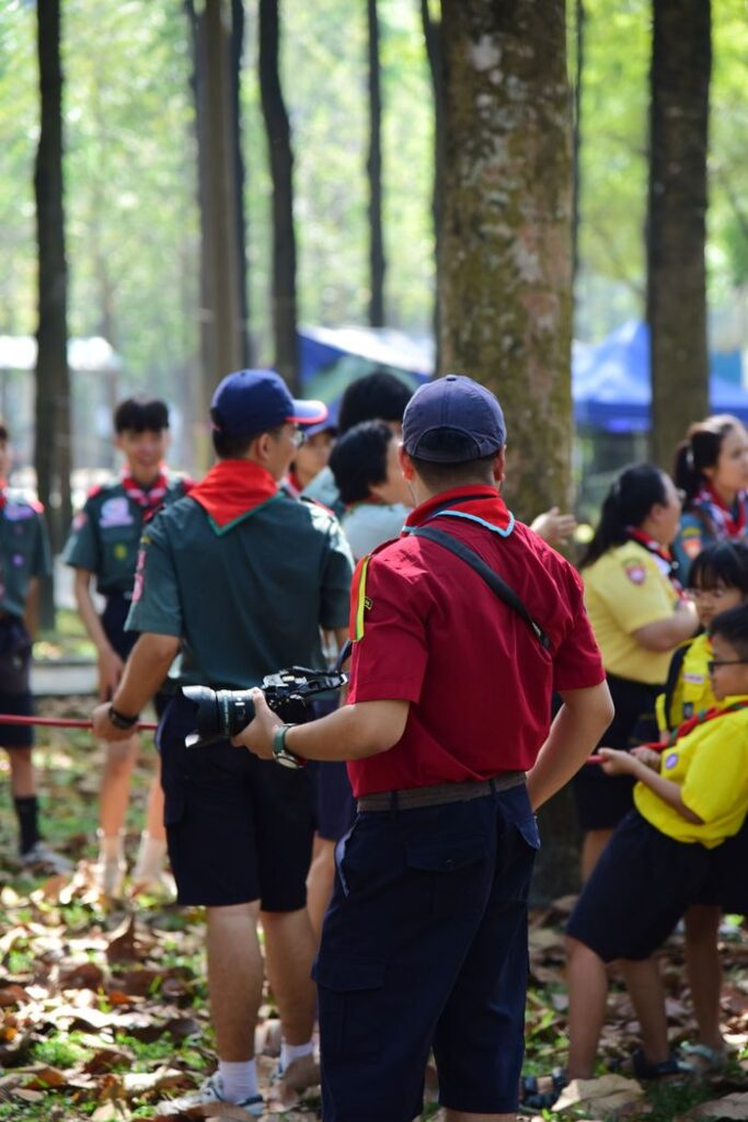 A vibrant group of scouts gathers outdoors in a lush forest setting for activities.