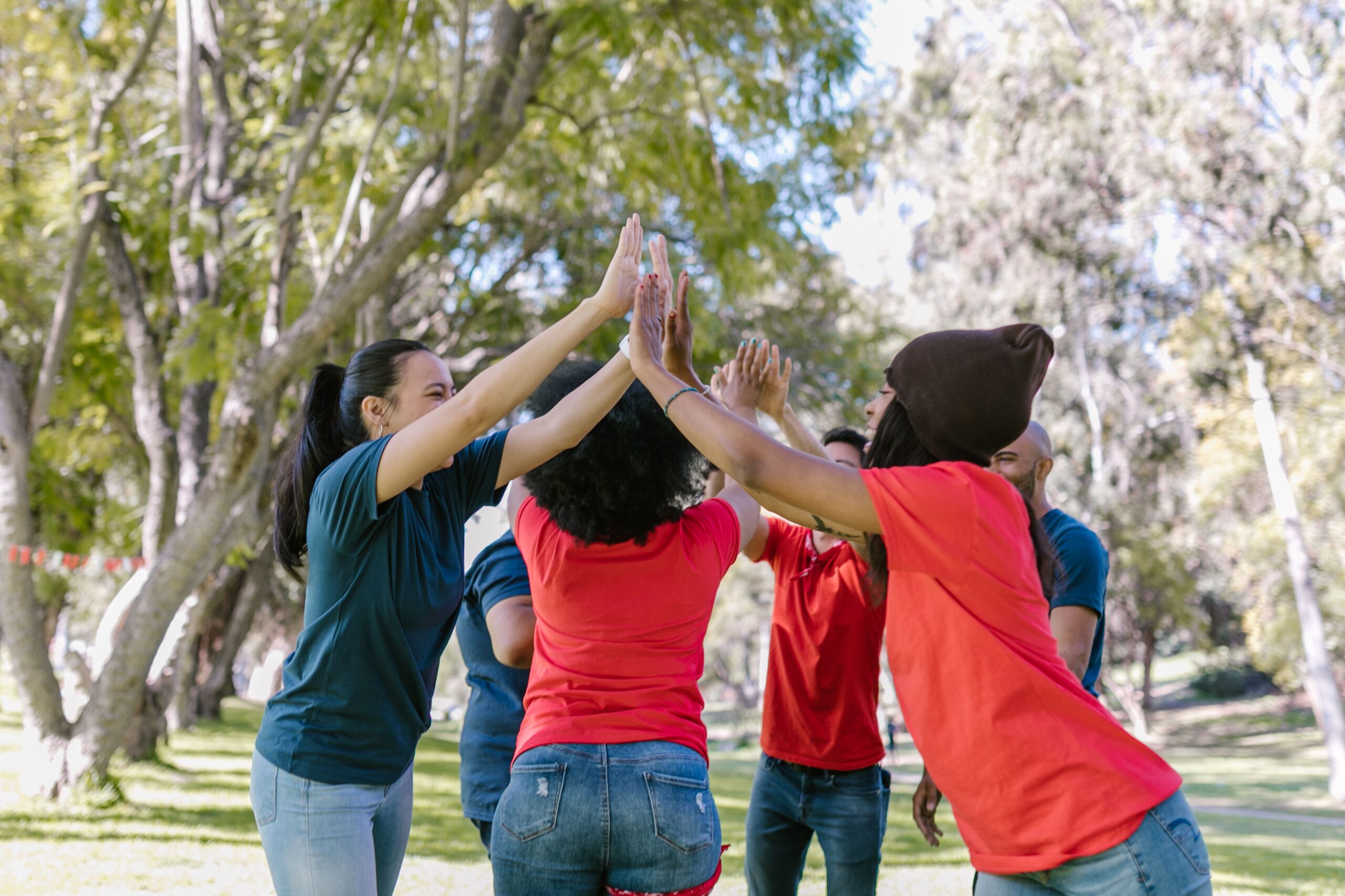 A group of diverse adults enjoying team building activities outdoors, showcasing unity and fun.